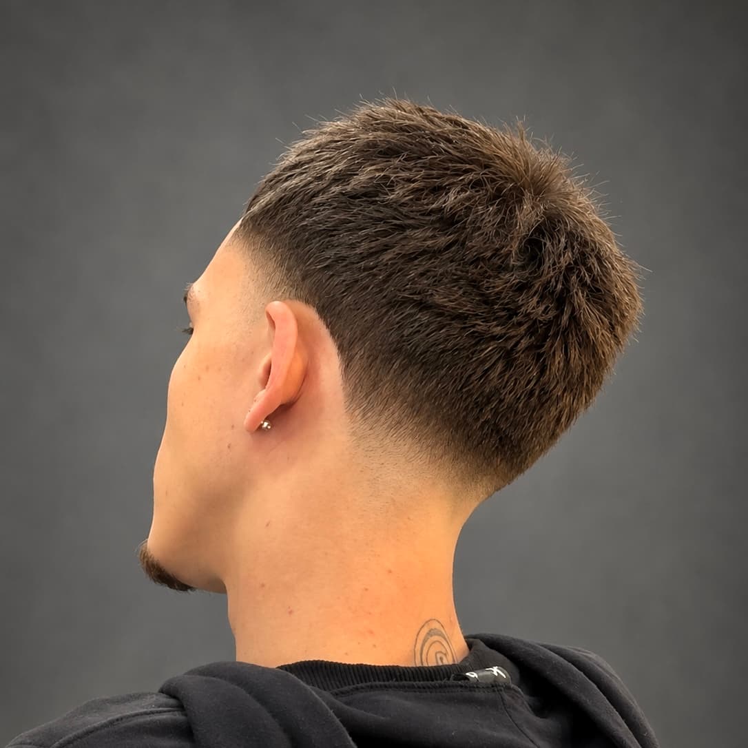 Nuca de um corte curto e texturizado no topo, com degradê baixo abrindo nas laterais